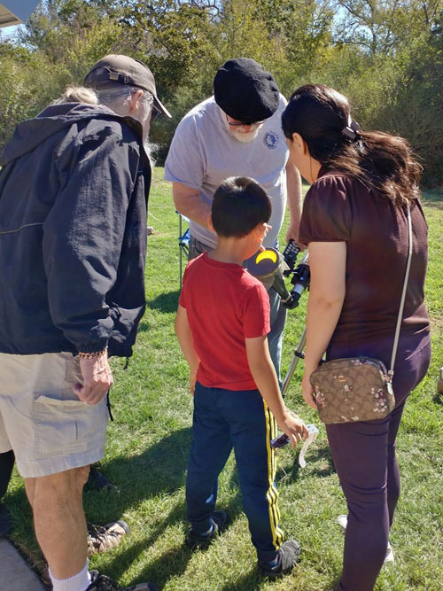 Family looks at phase of eclipse on Tim's telescope