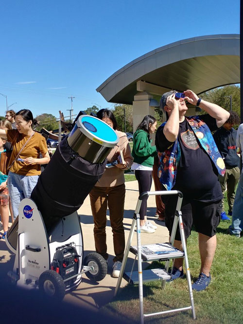 Tom peeks at eclipse through solar glasses